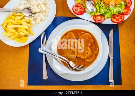 Cuisine traditionnelle de l'Alentejo - langue de vache dans une sauce servie avec salade, riz et frites, Portugal, Europe Banque D'Images