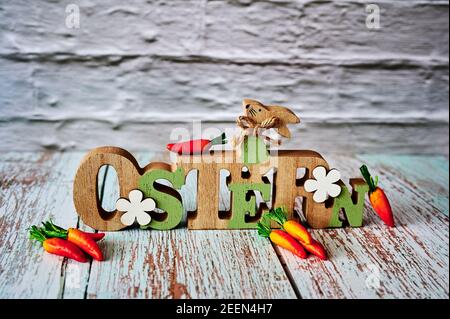 Panneau en bois avec un lapin de Pâques et des carottes pour la décoration. Le texte est allemand pour Pâques. Banque D'Images
