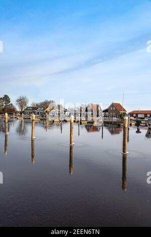 Réflexions des poteaux d'amarrage sur la glace dans la Marina à Vennemeer, Warmond, Kaag & Braasem, Hollande du Sud, pays-Bas. Banque D'Images