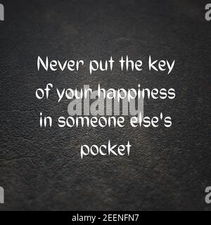 Citation de «ne jamais mettre la clé de votre bonheur dedans la poche de quelqu'un d'autre » sur fond de béton Banque D'Images