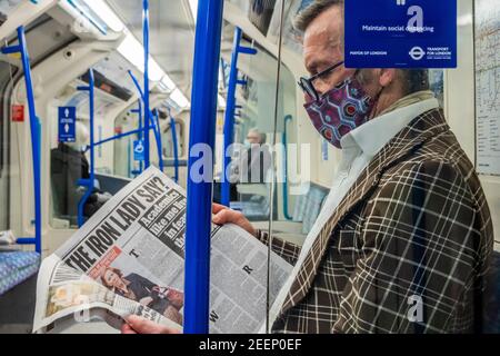 Londres, Royaume-Uni. 16 février 2021. Un homme dans une combinaison de masques de veste audacieux a lu ce que la dame de fer pourrait faire de tout - le métro est calme juste après l'heure de pointe pendant le nouveau lockdown national, rester à la maison, instructions. La plupart des voyageurs portent des masques car ils sont déjà obligatoires. Crédit : Guy Bell/Alay Live News Banque D'Images