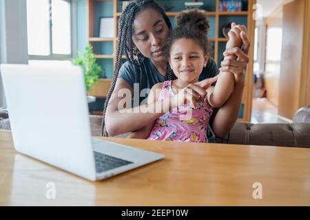 La mère et la fille lors d'un appel vidéo avec un médecin. Banque D'Images