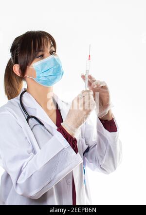Portrait d'une femme médecin confiante, belle et jeune. Le médecin tient la seringue dans sa main et regarde attentivement BMS Art Barbara Smok Banque D'Images