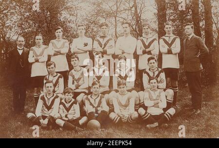 Carte postale photographique vintage du début du XXe siècle montrant une équipe de football de la communauté School Boy ou Kids. Banque D'Images