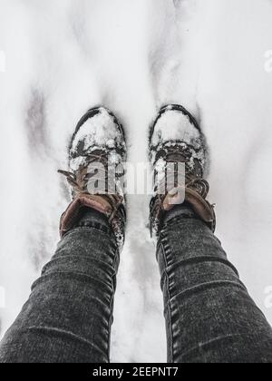 Marcher sur un sol couvert de neige. Bottes de randonnée couvertes de neige. En hiver, activités de plein air Banque D'Images