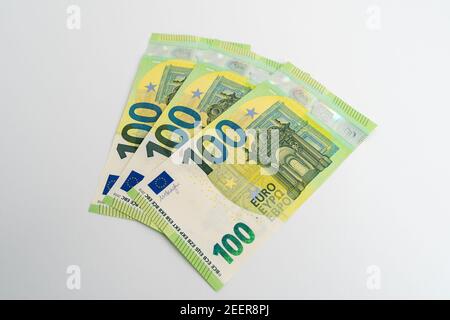 Nouveaux billets verts de cent euros sur fond blanc de studio. 100 euros reposant sur une surface blanche comme monnaie en Europe. Banque D'Images