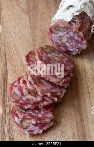Salami en tranches séchées à l'air - fond en bois Banque D'Images
