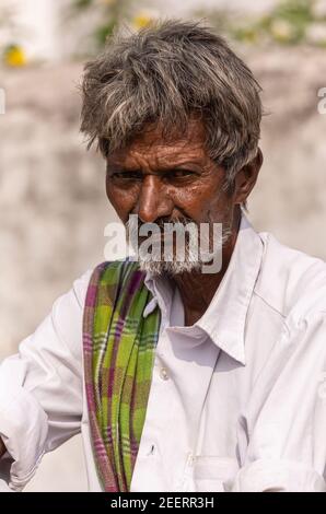 Ayodhya, Karnataka, Inde - 9 novembre 2013 : portrait d'un agriculteur plus âgé avec une chemise blanche et une poupe verte. Banque D'Images