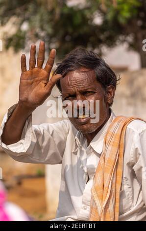 Ayodhya, Karnataka, Inde - 9 novembre 2013 : portrait d'un jeune agriculteur agité avec chemise blanche et châle jaune, cheveux noirs et moustache avec un sourire. Banque D'Images