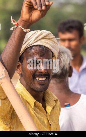 Ayodhya, Karnataka, Inde - 9 novembre 2013 : portrait d'un jeune fermier souriant qui s'incline contre le poteau, a du turban et une chemise jaune avec une moustache noire Banque D'Images