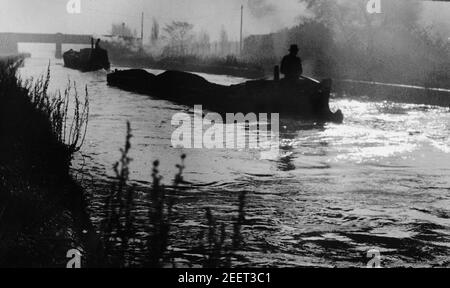 Bateaux à rames transportant du charbon un matin brumeux le long du Tipton Canal dans le West Midlands 'Black Country' en 1953 Banque D'Images