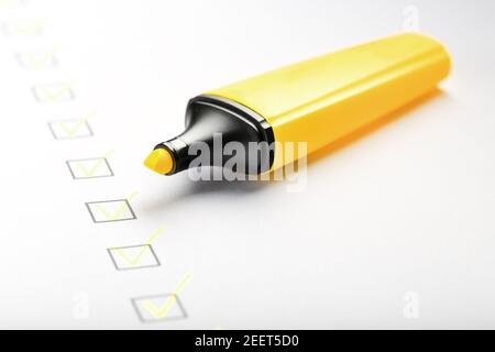 Marqueur jaune avec marqueurs sur la feuille de liste de contrôle. Concept de la tâche terminée de la liste de contrôle. Banque D'Images