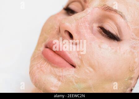 Masque enzymatique en cours de séchage sur le visage d'une femme gros plan. Rajeunissement et rajeunissement en cosmétologie. Banque D'Images