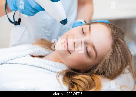 Une belle fille attrayante obtient une procédure de levage fraîche avec un pistolet de dioxyde de carbone non-injection. Banque D'Images