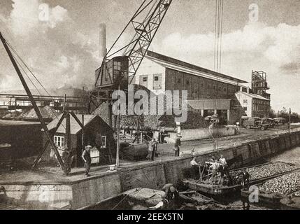 Une vieille photographie de presse des travailleurs de barges déchargeant la betterave à sucre dans une usine qui se trouve à Ely, en Angleterre. Cette photo a été prise vers 1940, l'usine a été construite en 1928 par Joanness Van Rossum et fermée en 1981. L'usine possédait sa propre usine de fabrication de Jam de Saint-Martin à Brays Lane. Banque D'Images