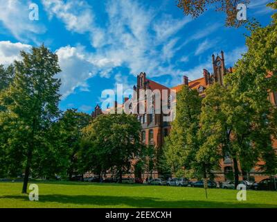 Vue inclinée sur les bâtiments de la cathédrale devant un petit vert garez-vous dans la ville de Wroclaw par beau temps nuageux Banque D'Images