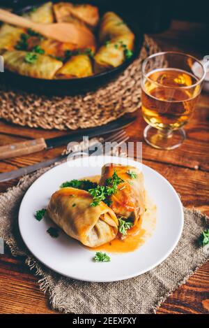 Portion de rouleaux de chou farcis à la viande hachée sur blanc Assiette servie avec du persil haché Banque D'Images