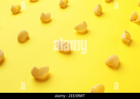 Pâtes lumaconi sur fond jaune, foyer sélectif. Banque D'Images