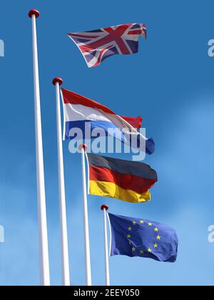 Drapeaux de la France, de l'Allemagne et de l'Union européenne sur les mâts de drapeaux. Drapeau du Kongdom Uni quitte le mât et vole loin. Concept du Brexit. Bleu Banque D'Images