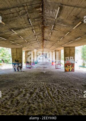 Varsovie juin 17 2018 chemin par sable sous pont en béton avec graffiti coloré sur les piliers Banque D'Images