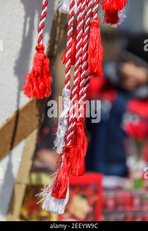 Une touche rouge et blanche sur un kiosque dans la rue vendant le martisor, une coutume de Roumanie au début du printemps. Banque D'Images