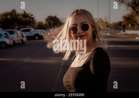Portrait d'une jeune femme hispanique portant des lunettes de soleil et un dessus noir Banque D'Images