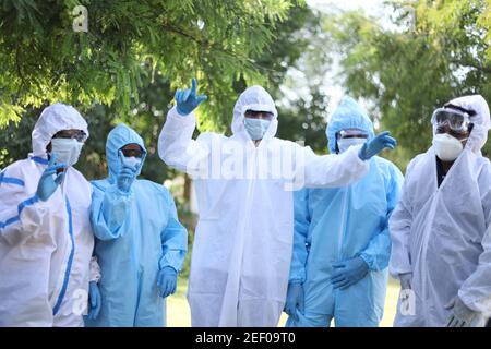 Groupe optimiste de travailleurs médicaux portant des vêtements de protection dansant heureusement Banque D'Images