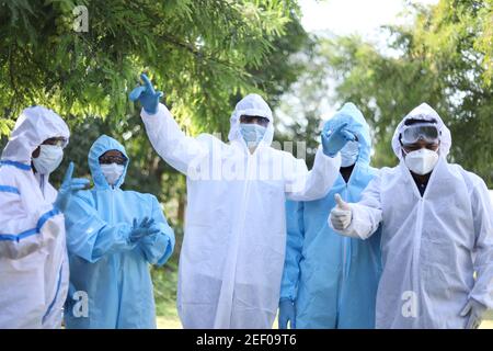 Groupe optimiste de travailleurs médicaux portant des vêtements de protection dansant heureusement Banque D'Images