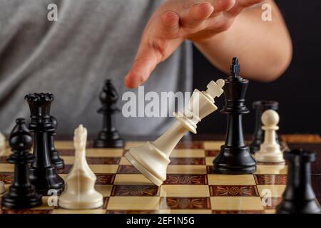 Une image rapprochée de la fin d'une échecs est venue où le joueur perdant démissionne en renverse son roi. L'image montre que le roi tombe. Imag. Polyvalente Banque D'Images