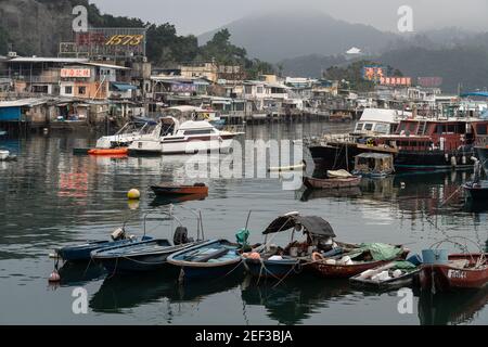Yau Tong, Hong Kong - Mars 15 2019: Les bateaux dans le port d'abri de typhon Sam Ka Tsuen font face au village de pêche de Lei Yue Mun célèbre pour son repos de fruits de mer Banque D'Images