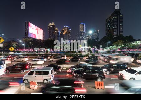 Trafic capturé avec des mouvements flous dans le quartier moderne du centre-ville de Jakarta le long d'une autoroute surpeuplée à l'heure de pointe de nuit à Jakarta, capitale de l'Indonésie Banque D'Images