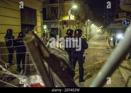 Des policiers sont en alerte dans la rue pendant la manifestation.Pablo Hasél, un rappeur catalan, a été arrêté le mardi matin du 16 février et condamné à neuf mois et un jour de prison par la Chambre d'appel de la Cour nationale en septembre 2018, en plus du paiement d'une amende d'environ 30,000 euros accusé de glorifier le terrorisme, d'insulter et d'offenser la monarchie et les forces de sécurité de l'état. Dans l'après-midi du même jour, à Barcelone, des centaines de personnes ont manifesté contre son arrestation, la manifestation s'est terminée par des conflits avec la police et plusieurs guirlandes Banque D'Images