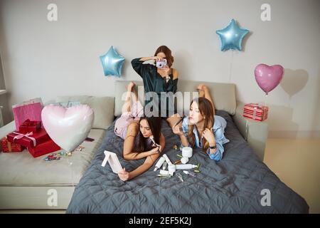 Des amies féminines appliquant la poudre à leurs visages à l'aide de brosses Banque D'Images