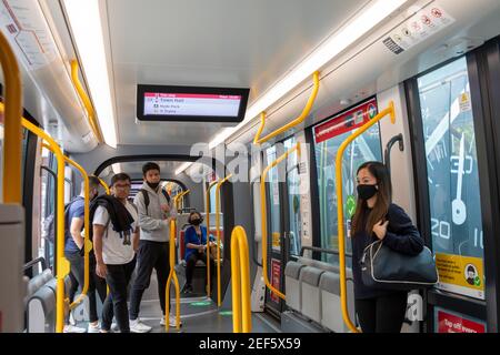 Navetteurs train léger de Sydney une dame asiatique porte le faciemark pendant Pandémie du virus Covid 19, Sydney, Nouvelle-Galles du Sud, Australie Banque D'Images