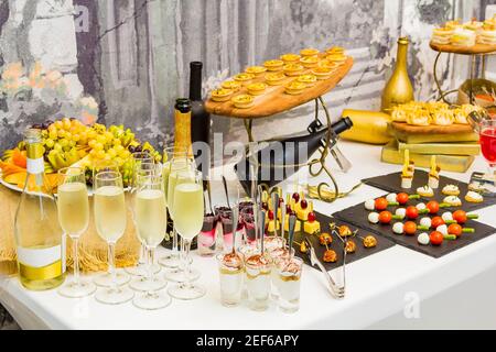 Délicieux desserts sur la table du banquet. Fruits, cocktails, vin, crème glacée à la confiture, biscuits à la crème. Banque D'Images