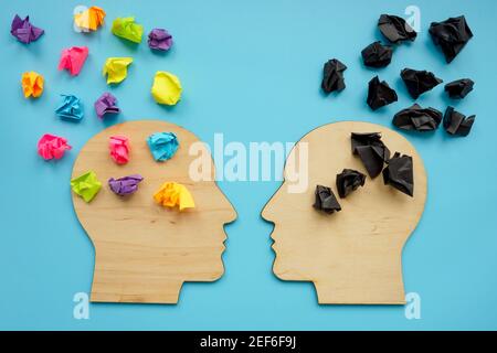 Concept de pensée négative et positive. Formes de tête avec boules de papier de couleur. Banque D'Images