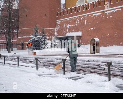 Moscou. Russie. 12 février 2021. Les employés des services publics retirent la neige à l'aide d'un souffleur à neige et de pelles lors d'une chute de neige près du mur du Kremlin, à la tombe de Banque D'Images