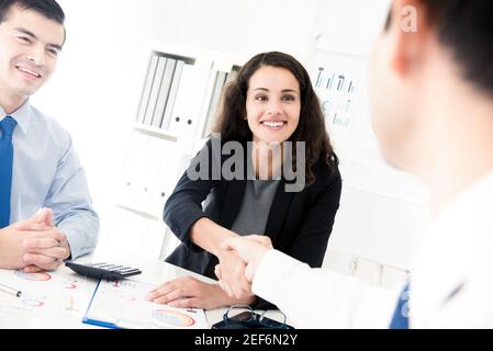 Femme d'affaires qui fait poignée de main avec un homme d'affaires à la réunion à le bureau Banque D'Images