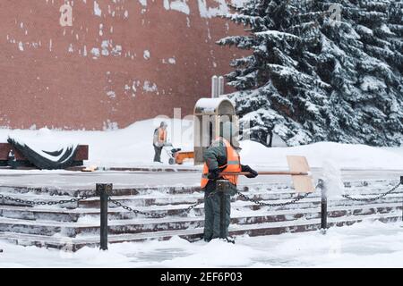 Moscou. Russie. 12 février 2021. Les employés des services publics retirent la neige à l'aide d'un souffleur à neige et de pelles lors d'une chute de neige près du mur du Kremlin, à la tombe de Banque D'Images