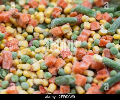 Légumes dépolis colorés carottes, maïs et pois en tas Banque D'Images