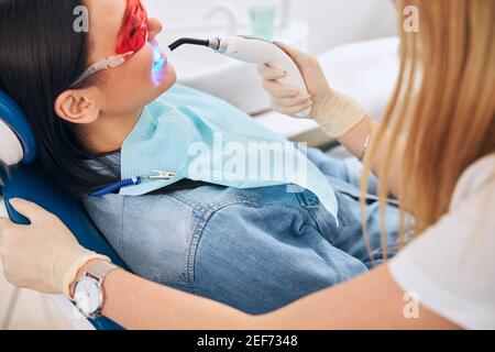 Un professionnel de la santé attentif qui effectue un contrôle des dents dans l'armoire Banque D'Images