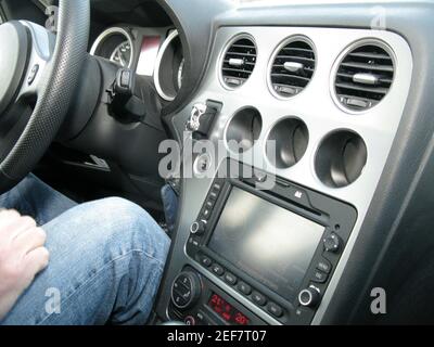 Main en jambes dans le Jean derrière le volant de voiture Banque D'Images