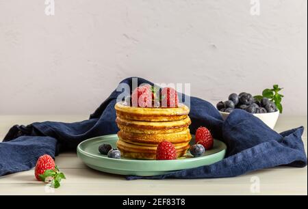 Crêpes américaines savoureuses aux framboises, aux bleuets et au miel. Banque D'Images