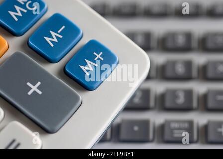 Symboles mathématiques sur une calculatrice et un clavier d'ordinateur dans l'arrière-plan Banque D'Images