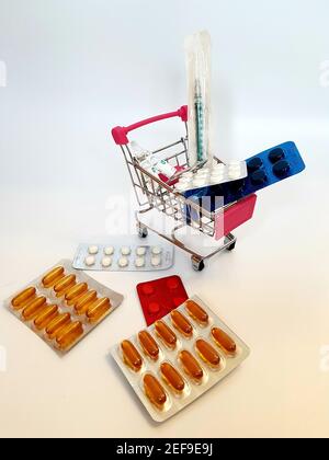 Chariot alimentaire avec pilules sur fond blanc. Concept de médecine, de traitement, d'utilisation, d'achat et de vente de médicaments. Banque D'Images