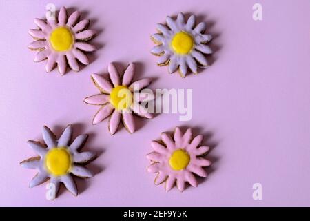 Vue de dessus des biscuits en forme de fleurs isolées sur fond violet avec espace de copie pour le texte ou la conception Banque D'Images