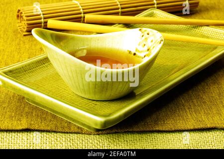 Vue en grand angle de la sauce soja dans un bol avec une paire de baguettes Banque D'Images