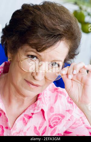 Portrait d'une femme âgée qui peche au-dessus de ses lunettes Banque D'Images