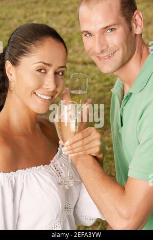 Portrait of a young couple holding champagne flutes Banque D'Images