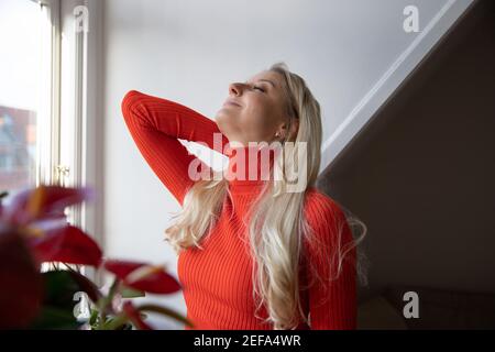Elle s'étire le dos, elle se sent bonne, saine et positive. Elle est à la maison et c'est l'hiver Banque D'Images